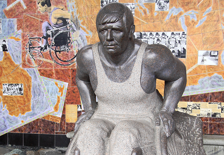 Une statue de Rick Hansen dans son fauteuil roulant en marbre et en béton.
