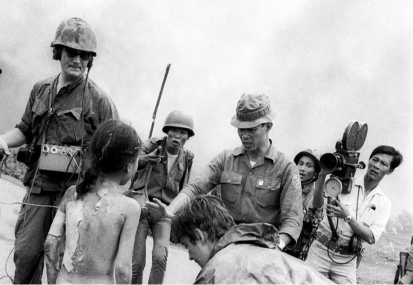 Kim Phúc, 9-year-old Vietnamese girl, tore off her burning clothes and is surrounded by journalists and soldiers.